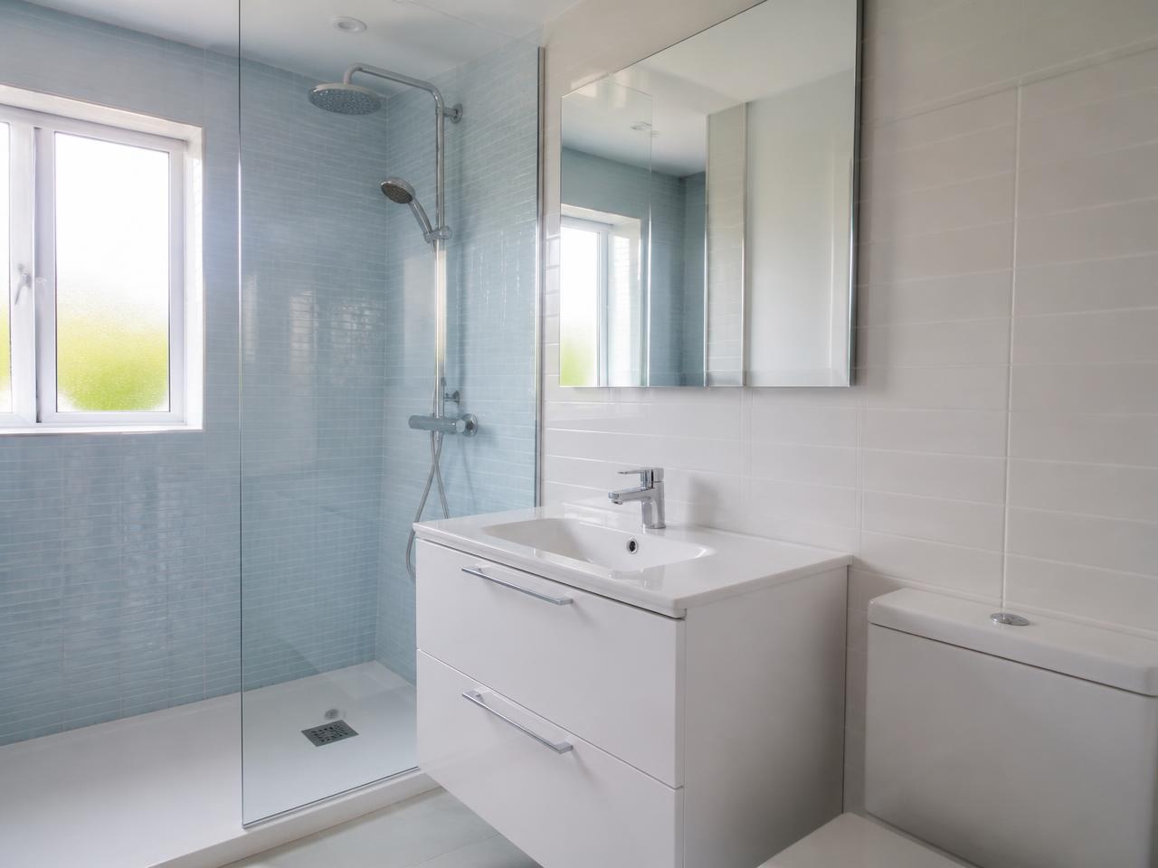 Salle de bains rénovée avec douche classique et meuble vasque